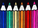 many colored pencils lined up in a row on a black background