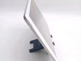 a white tablet computer sitting on a stand on a white surface