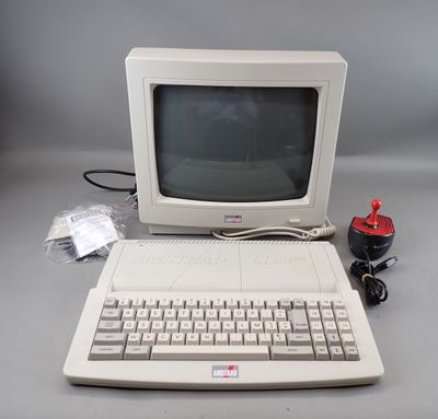 un vieil ordinateur avec un clavier et une souris posés sur la table