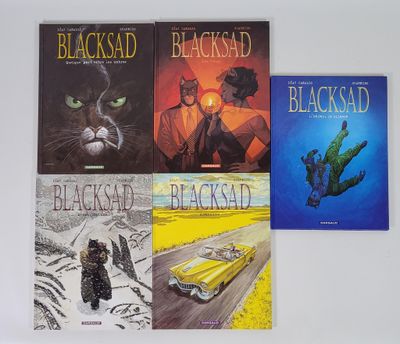 trois livres posés sur une table blanche, avec un chat et une voiture