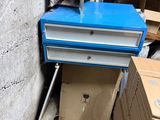a blue box sitting on top of a pallet next to a wall