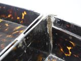 a close up of a tortoise shell tray with a crack in it