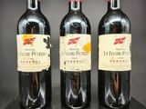 trois bouteilles de vin rouge sont alignées sur une étagère