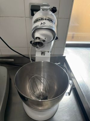 a mixer with a whisk inside of it on a counter