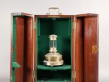 une petite boîte en bois contenant un objet en laiton