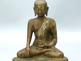 statue en bronze représentant une personne assise sur une estrade