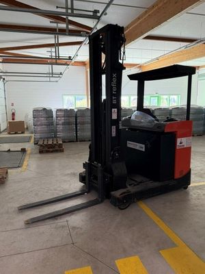 a forklift in the middle of a warehouse with pallets in the background