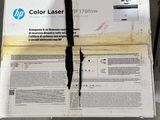 une boîte contenant des imprimantes laser HP posée par terre