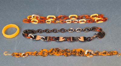 three different bracelets and a rubber band on a blue surface