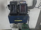 une photo d'une station-service avec deux pompes et une machine verte