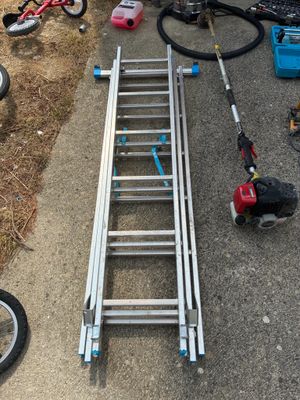 a ladder that is sitting on the ground next to a bike