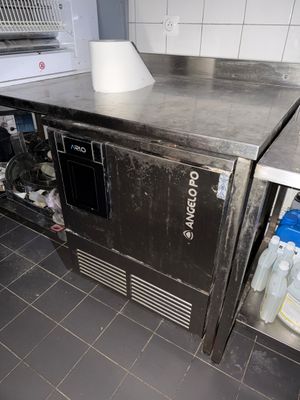 plan de travail en acier inoxydable dans une cuisine professionnelle, équipé d'un évier et d'un four