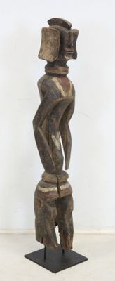 une image représentant une statue en bois d'un homme portant un chapeau sur la tête