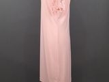 a pink dress on a mannequin stand against a gray background