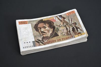 une liasse de billets posée sur une table noire