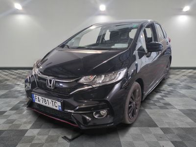 La Honda Fit est garée dans le garage dont le sol est à damier.