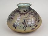 a glass vase with flowers on it sitting on a table