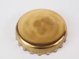 a close up of a brass bottle cap on a white surface