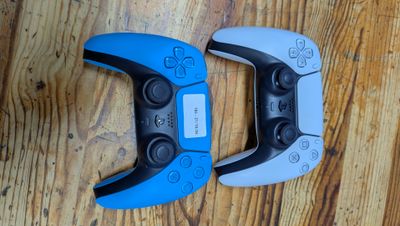 deux manettes de jeu vidéo posées sur un parquet