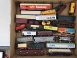 une boîte remplie de petits trains et d'autres véhicules miniatures