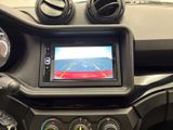 the dashboard of a car with a monitor showing a view of a road