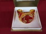 bracelet in a box with a red and gold design on it