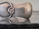 a silver spoon with a knot on it sitting on a table