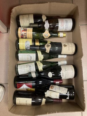 plusieurs bouteilles de vin dans un carton posé sur le sol