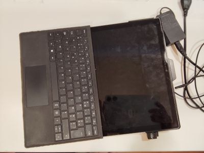 un ordinateur portable posé sur une table avec un chargeur