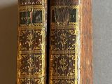 Deux vieux livres sont posés l'un sur l'autre sur une table