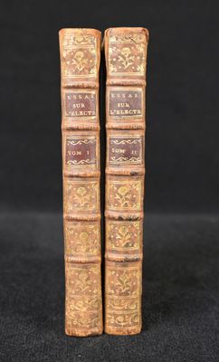a pair of old books sitting on top of a black surface