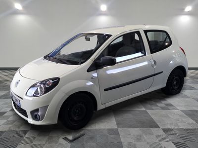 la photo d'une petite voiture blanche garée sur un sol en damier