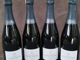 quatre bouteilles de vin sont alignées sur une table