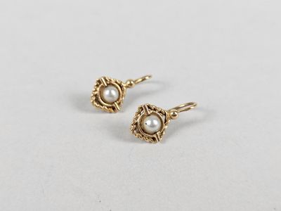 a pair of pearl earrings on a white surface