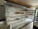 de nombreuses étagères vides dans un magasin où sont disposés des produits alimentaires