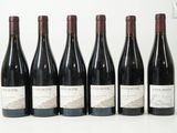 six bouteilles de vin sont alignées sur une table