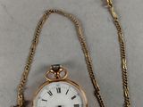an antique pocket watch with a chain attached to it