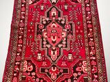 a red rug with an ornate design on a white background