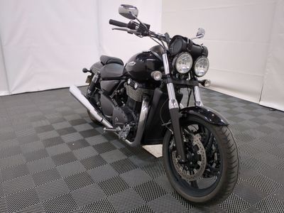 une moto noire garée sur un sol à damier