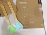 two wooden spoons sitting next to a package of kitchen utensils