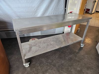 a stainless steel table on wheels in a kitchen