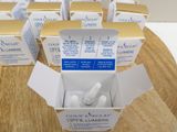 several boxes of toothpaste sitting on top of a wooden cutting board