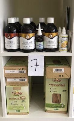 de nombreuses bouteilles de liquide posées sur une étagère à côté de cartons