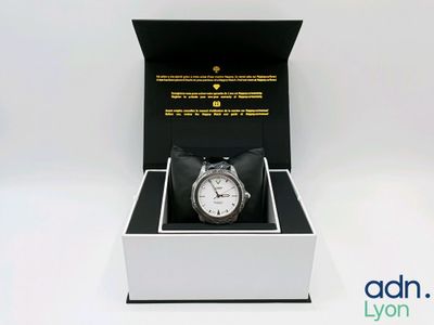 l'image d'une montre dans une boîte sur une surface blanche