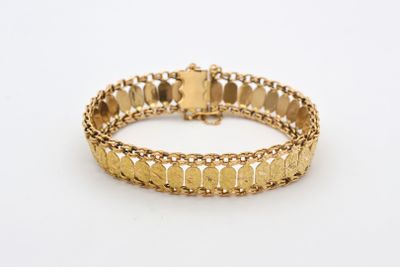 a close up of a gold bracelet on a white surface