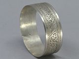 a close up of a silver ring on a gray surface