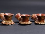 three small vases are sitting on top of a black surface
