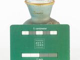 a small green card sitting on top of a vase