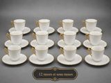 twelve cups and saucers with gold trims on them