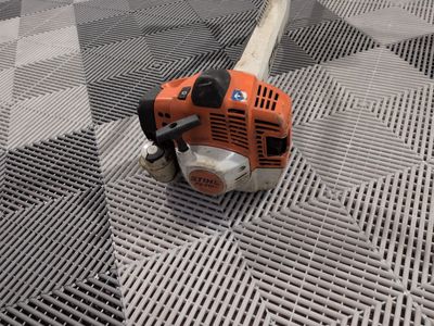 a chainsaw that is laying on a metal floor
